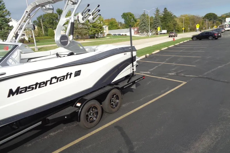Slide: The Image of 2020 MasterCraft XT23 boat on trailer in parking lot, sunny day. - 3