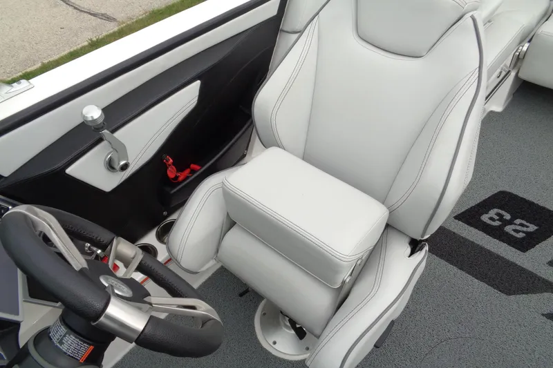Slide: The Image of 2020 MasterCraft XT23 boat interior with sleek white captain's seat and steering wheel. - 32
