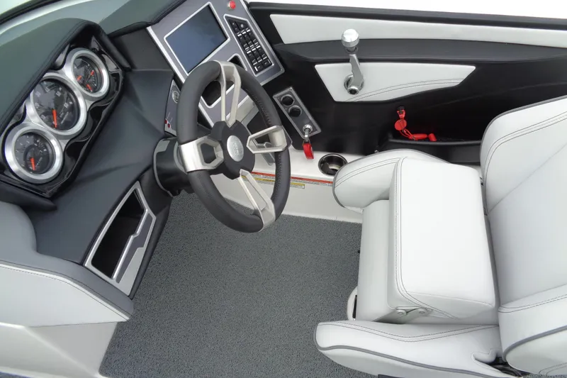 Slide: The Image of 2020 MasterCraft XT23 boat interior with steering wheel, gauges, and white seating. - 33
