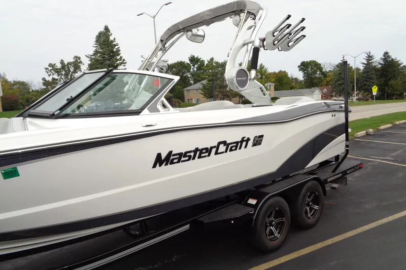 Slide: The Image of 2020 MasterCraft XT23 boat on trailer in parking lot, side view. - 44