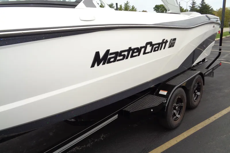 Slide: The Image of 2020 MasterCraft XT23 boat on trailer, side view with logo visible. - 45