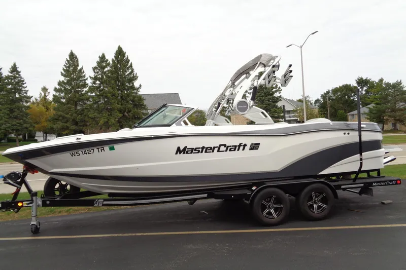 Slide: The Image of 2020 MasterCraft XT23 boat on trailer, parked in suburban neighborhood. - 63