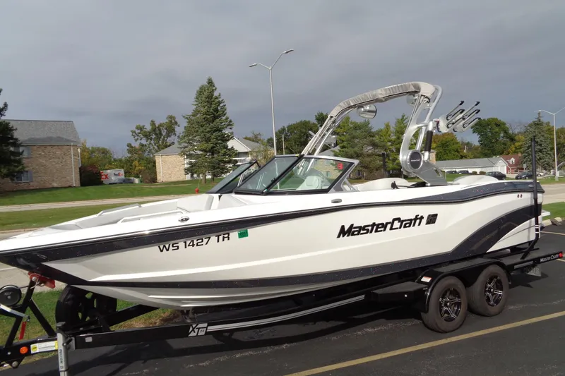Slide: The Image of 2020 MasterCraft XT23 boat on trailer, parked in suburban area. - 69