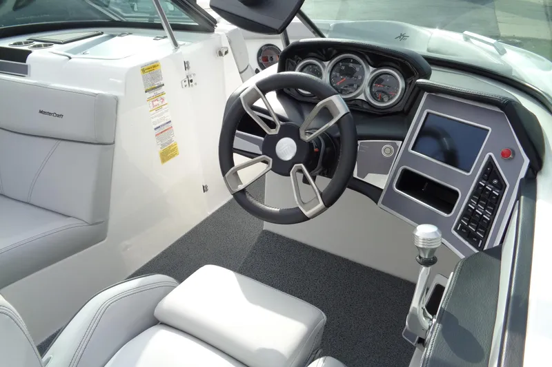 Slide: The Image of 2020 MasterCraft XT23 boat dashboard with steering wheel, gauges, and touchscreen display. - 71