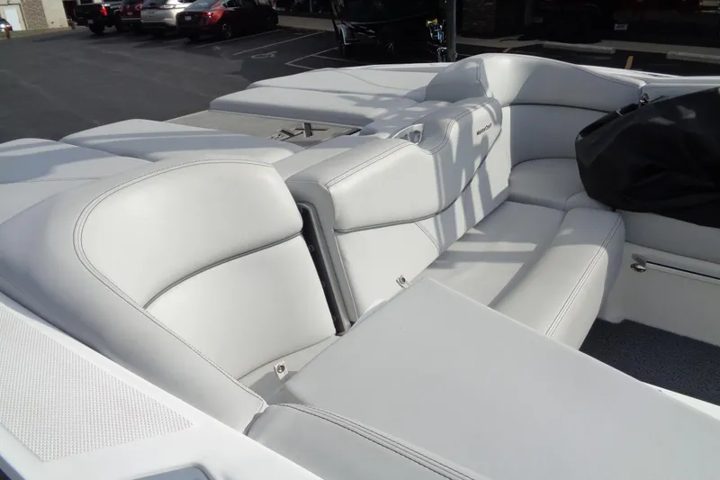 Slide: The Image of 2020 MasterCraft XT23 boat interior with white leather seating in a parking lot. - 72