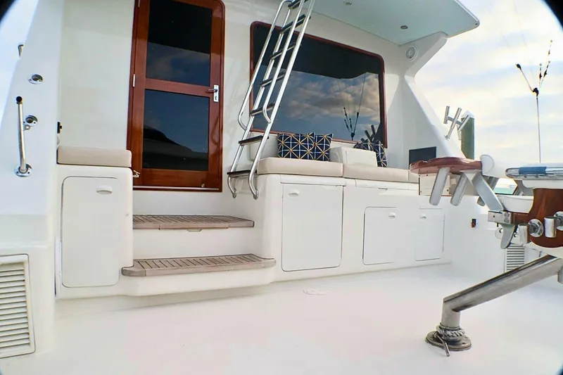 Slide: The Image of 2001 Donzi 73 Sport Yacht deck with seating, ladder, and wooden door. - 4