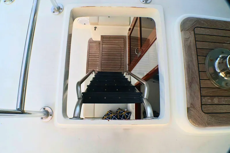 Slide: The Image of Staircase leading below deck on 2001 Donzi 73 Sport Yacht, featuring wooden and metal details. - 51