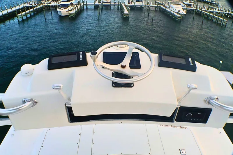Slide: The Image of Helm of 2001 Donzi 73 Sport Yacht overlooking marina with docked boats. - 61