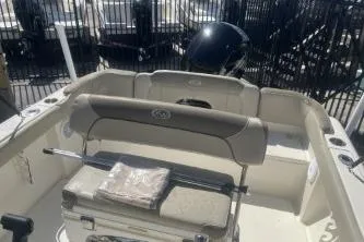 Slide: The Image of 2022 Key West 203 DFS boat interior with seating and motor, parked outdoors. - 11