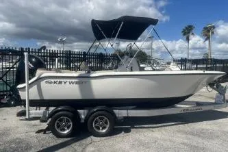 Slide: The Image of 2022 Key West 203 DFS boat on trailer, parked outdoors under a cloudy sky. - 4