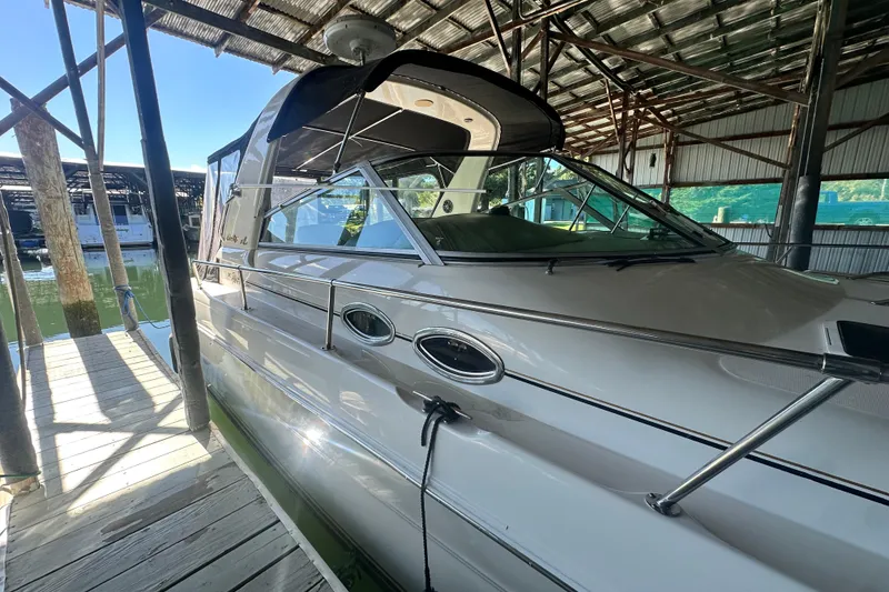 Slide: The Image of 2000 Sea Ray 310 Sundancer docked in a covered marina, side view. - 1