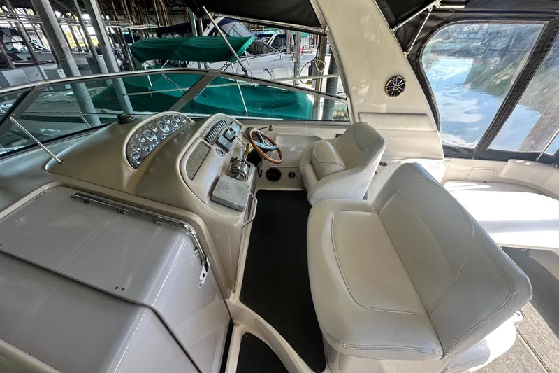 Slide: The Image of Interior view of a 2000 Sea Ray 310 Sundancer boat with white seating and control panel. - 14