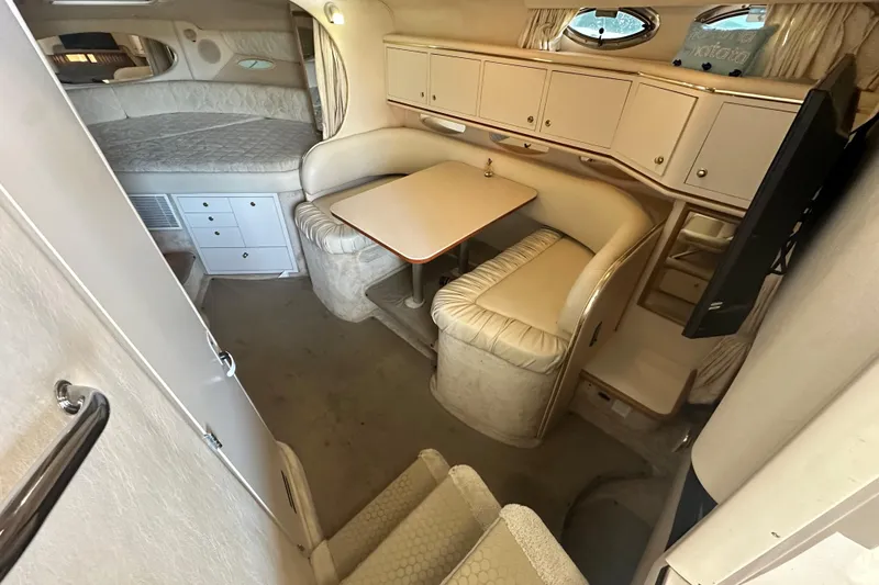 Slide: The Image of Interior of 2000 Sea Ray 310 Sundancer with cozy seating and compact dining area. - 26