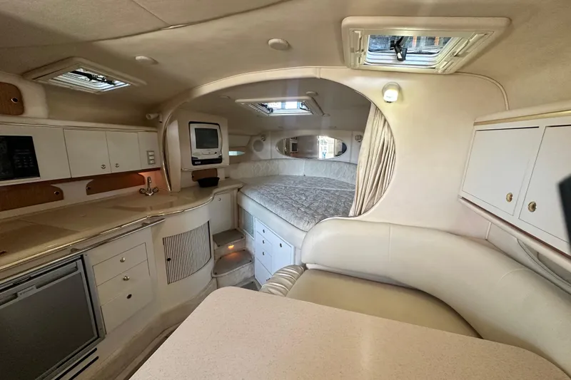Slide: The Image of Interior of 2000 Sea Ray 310 Sundancer yacht, featuring cozy cabin and kitchenette. - 28