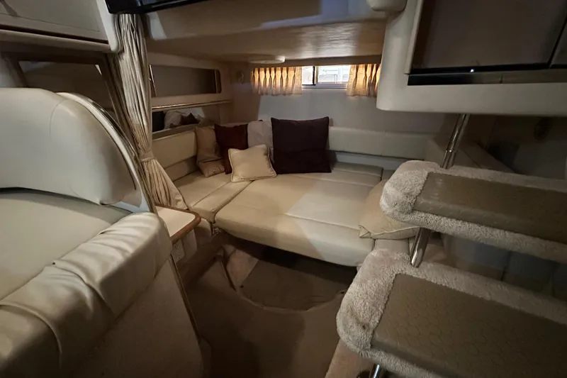 Slide: The Image of Interior of 2000 Sea Ray 310 Sundancer, featuring cozy seating and soft lighting. - 34