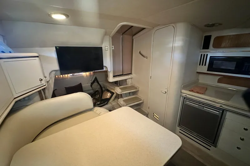 Slide: The Image of Interior of 2000 Sea Ray 310 Sundancer yacht with kitchenette and seating area. - 35