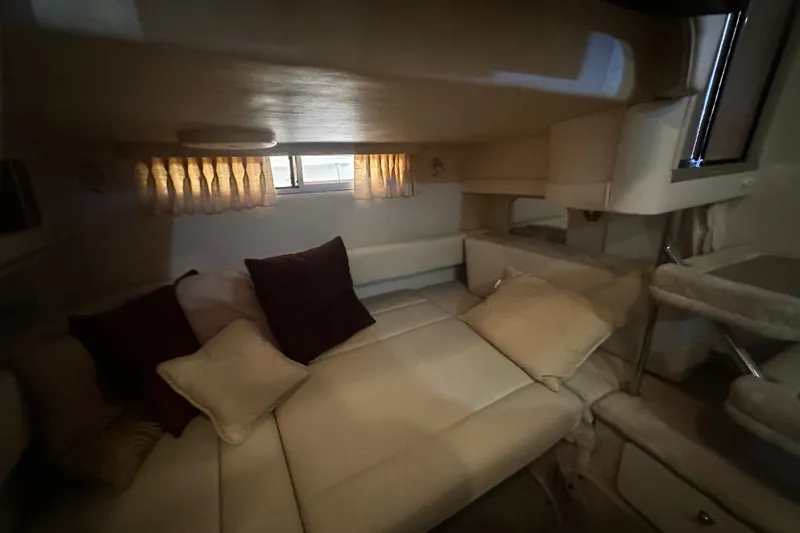 Slide: The Image of Cozy interior cabin of 2000 Sea Ray 310 Sundancer with plush seating and soft lighting. - 39
