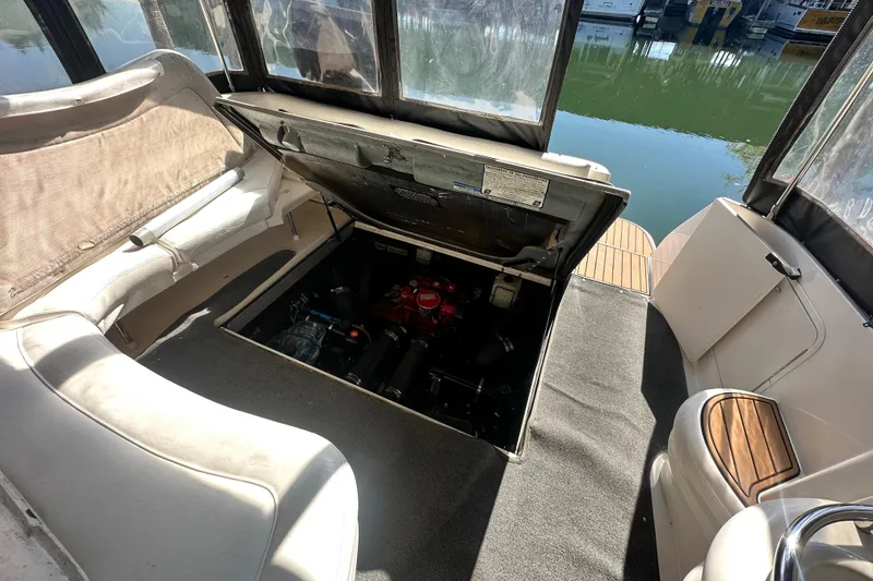 Slide: The Image of 2000 Sea Ray 310 Sundancer boat interior with open engine compartment, docked by the water. - 40
