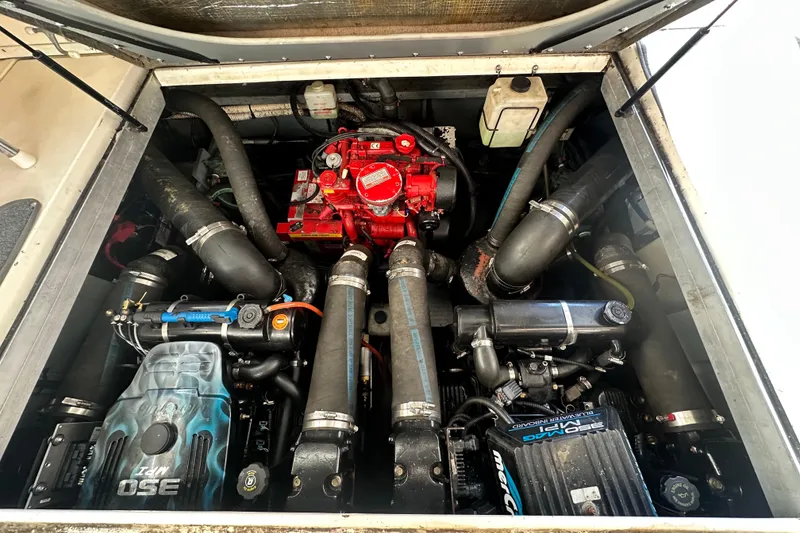 Slide: The Image of Engine compartment of a 2000 Sea Ray 310 Sundancer boat, showcasing detailed mechanical components. - 42