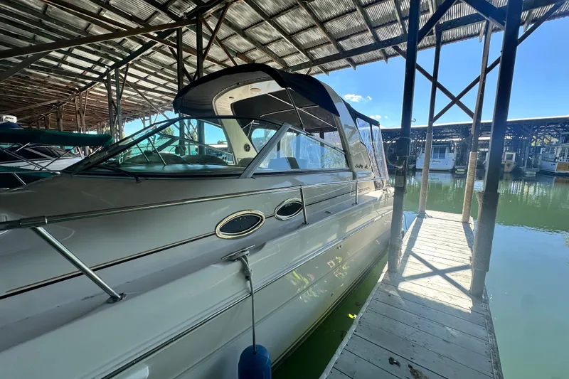 Slide: The Image of 2000 Sea Ray 310 Sundancer docked under a covered marina. - 9