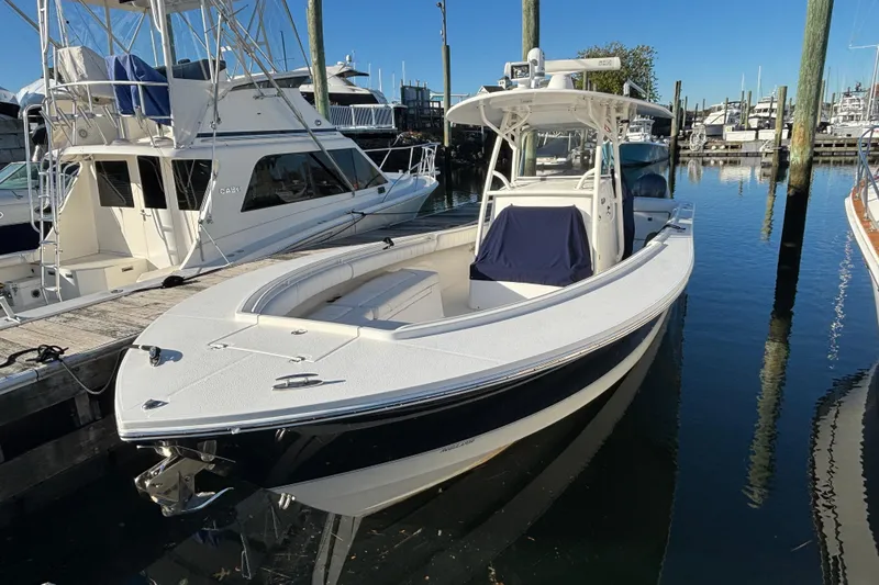 The Image of 2014 Regulator 34 boat docked in a marina, surrounded by other vessels. - 0