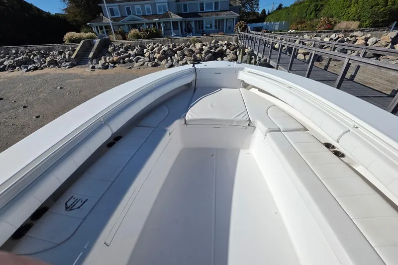 Slide: The Image of 2014 Regulator 34 boat with spacious seating, docked near a coastal house. - 12