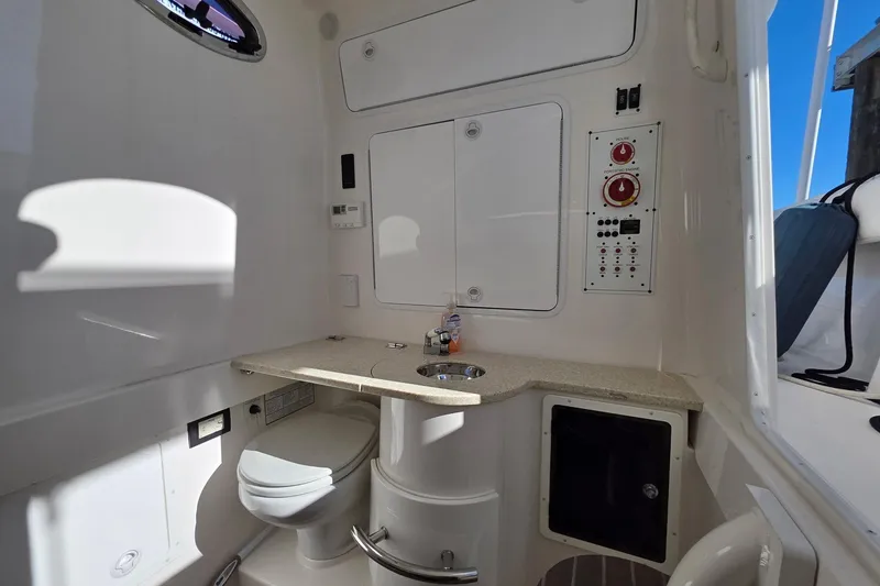 Slide: The Image of 2014 Regulator 34 boat interior with bathroom, sink, and control panel. - 13