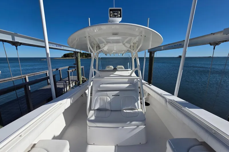 Slide: The Image of 2014 Regulator 34 boat docked by the ocean under clear blue skies. - 3