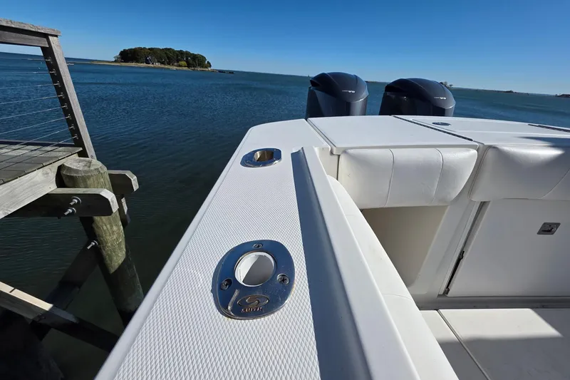 Slide: The Image of 2014 Regulator 34 boat docked by serene waters, featuring dual engines and sleek design. - 7