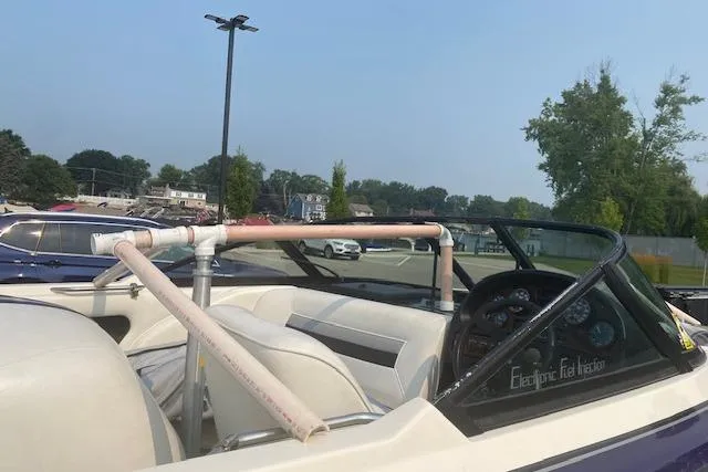 Slide: The Image of 1997 Malibu Echelon boat with custom PVC pipe modification, parked outdoors. - 12