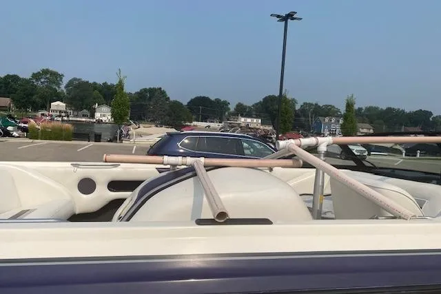 Slide: The Image of 1997 Malibu Echelon boat with makeshift PVC pipe structure in a parking lot. - 13