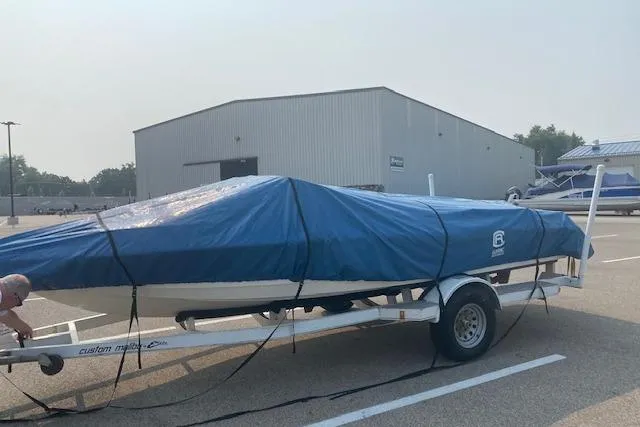 Slide: The Image of 1997 Malibu Echelon boat covered with blue tarp on trailer in parking lot. - 17