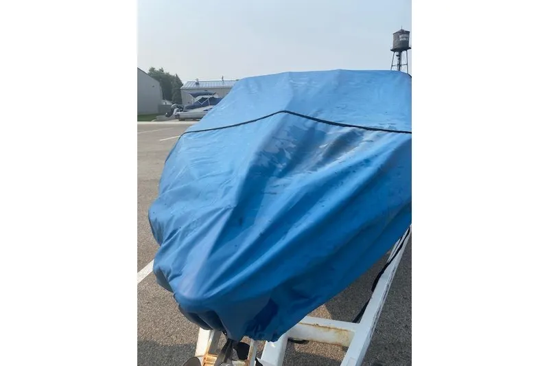 Slide: The Image of Covered 1997 Malibu Echelon boat with blue tarp in parking lot. - 20