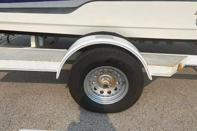 Slide: The Image of Trailer wheel of a 1997 Malibu Echelon boat on asphalt pavement. - 3