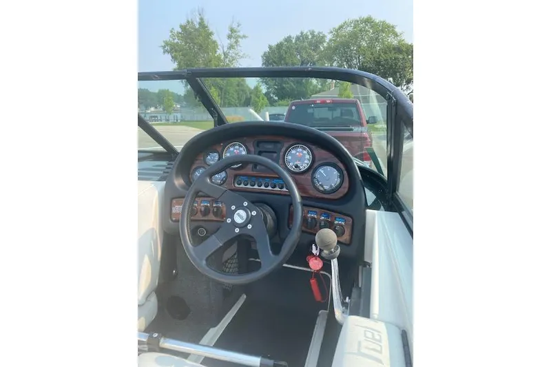 Slide: The Image of 1997 Malibu Echelon boat dashboard with steering wheel and gauges. - 5