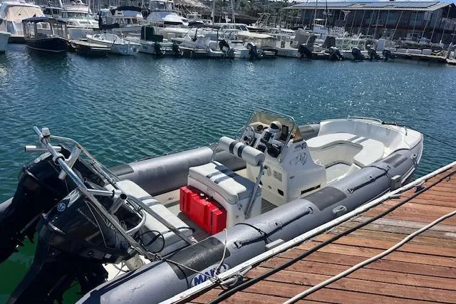Slide: The Image of 2001 Hysucat 650 boat docked at a marina, featuring dual outboard motors. - 9