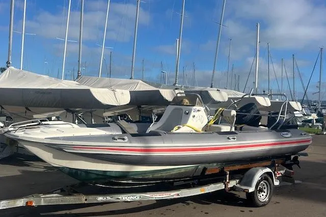 Slide: The Image of 2001 Hysucat 650 boat on trailer at marina with sailboats in background. - 8