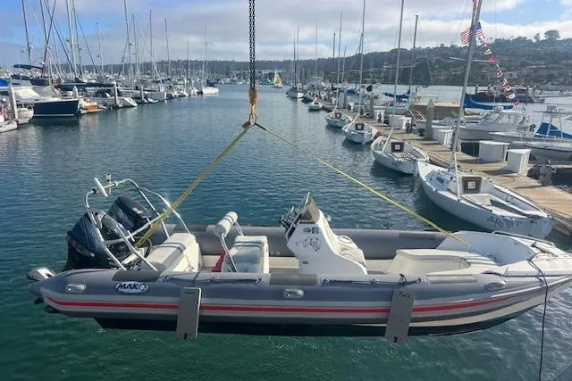 Slide: The Image of Hysucat 650 boat from 2001 being lifted at a marina with sailboats in the background. - 4
