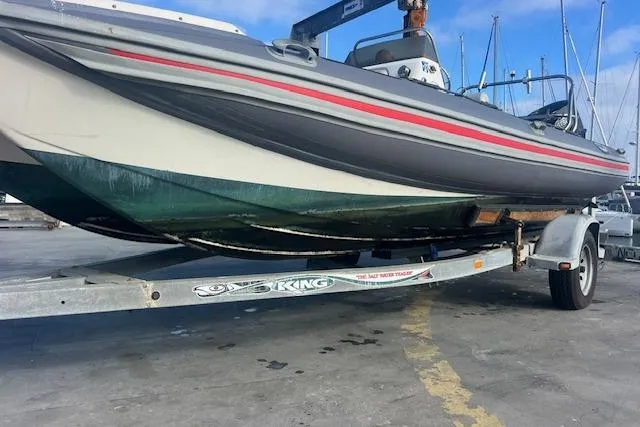 Slide: The Image of 2001 Hysucat 650 boat on trailer at marina, showcasing hull design. - 5