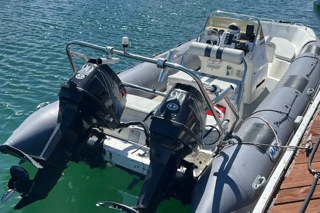 Slide: The Image of 2001 Hysucat 650 boat with dual 90 HP engines docked on clear water. - 1
