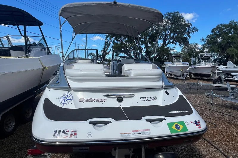 Slide: The Image of 2010 Sea-Doo 230 Challenger SP boat with canopy, parked in a marina. - 1