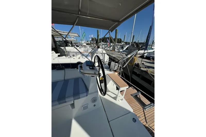 Slide: The Image of 2024 Beneteau Oceanis 37.1 yacht cockpit with steering wheel, docked at marina. - 10
