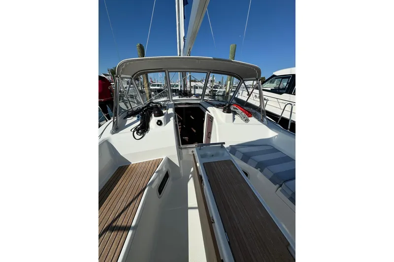 Slide: The Image of 2024 Beneteau Oceanis 37.1 sailboat cockpit with seating and helm, docked at marina. - 12