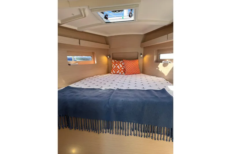 Slide: The Image of Cozy cabin interior of 2024 Beneteau Oceanis 37.1 yacht with nautical-themed bedding. - 19