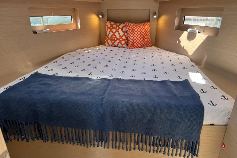 Slide: The Image of Cozy cabin interior of 2024 Beneteau Oceanis 37.1 with nautical-themed bedding. - 20