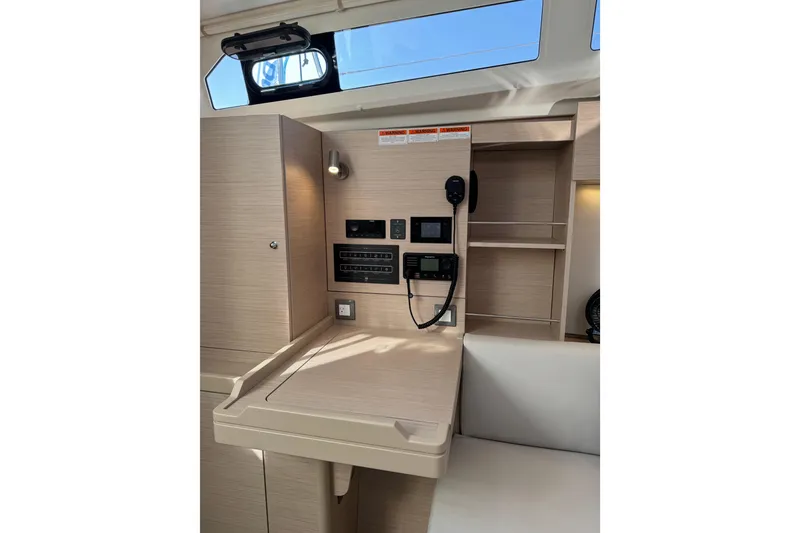 Slide: The Image of 2024 Beneteau Oceanis 37.1 interior with navigation panel and modern wood finish. - 23