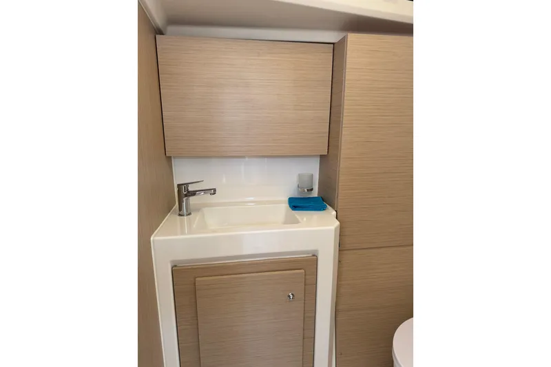 Slide: The Image of 2024 Beneteau Oceanis 37.1 yacht bathroom with modern sink and wooden cabinetry. - 24