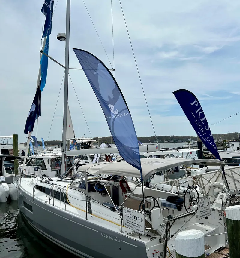 Slide: The Image of 2024 Beneteau Oceanis 37.1 sailboat docked at marina with flags. - 5
