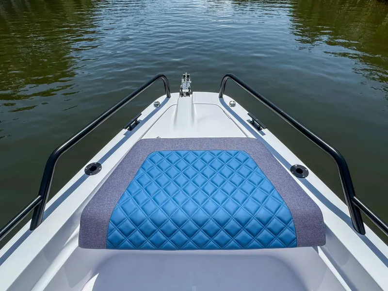 Slide: The Image of 2024 Axopar 37 Sun Top boat bow with blue cushioned seating. - 11