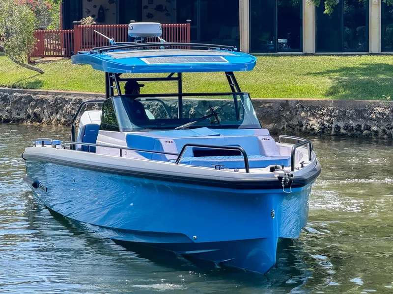 Slide: The Image of 2024 Axopar 37 Sun Top boat cruising on a calm waterway. - 2